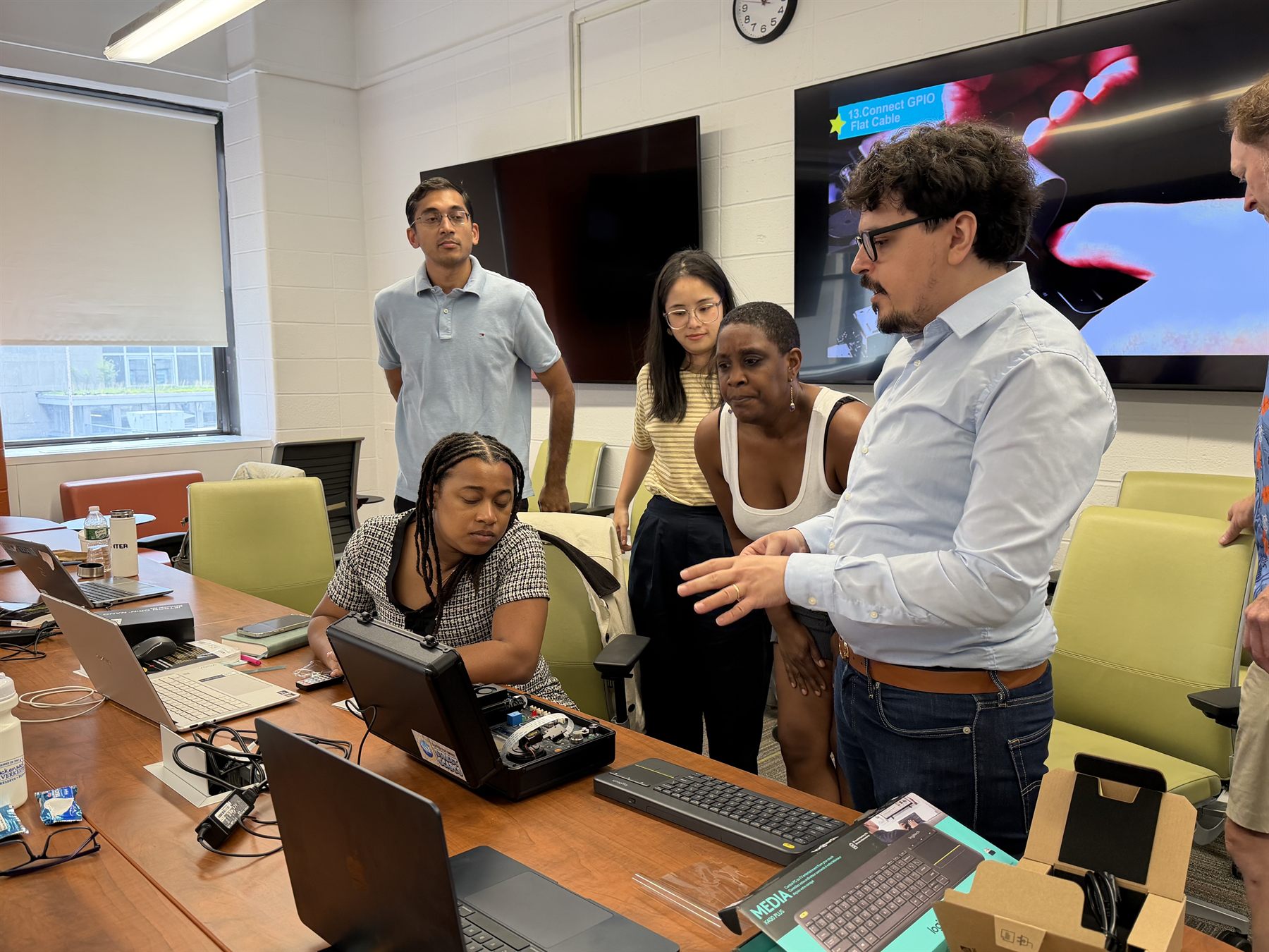 CS3 researchers and teachers examining a sensor and camera demonstration